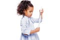 Little pretty fashionable african american girl in blue dress blowing soap bubbles on white background Royalty Free Stock Photo