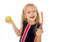 Little pretty female child choosing dessert holding unhealthy but tasty red candy licorice and apple fruit Royalty Free Stock Photo