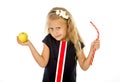 Little pretty female child choosing dessert holding unhealthy but tasty red candy licorice and apple fruit Royalty Free Stock Photo