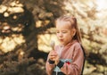 Little pretty girl blowing on dandelion summer in the park and making a wish Royalty Free Stock Photo