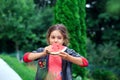 Little pretty girl eating a juicy watermelon in the garden. Children eat fruit outdoors. Healthy food for children Royalty Free Stock Photo