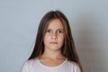 Little pretty girl with long hair, age 6-7 years old, expresses aggressive evil emotions