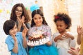 Little pretty girl with pendant chain on her head holds cake with candles at celebration of birthday. Royalty Free Stock Photo