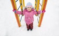 Little pretty girl on playground in winter