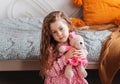 Little pretty girl plays with soft toy bear in children`s bedroom Royalty Free Stock Photo