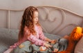 A little pretty girl plays with toys on her bed in the children`s room Royalty Free Stock Photo