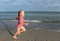 Little pretty girl on summer beach. Little blond girl runs along the beach and have fun