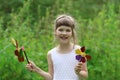 Little pretty girl with two windmills toys in summer Royalty Free Stock Photo