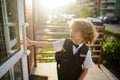 Little pupil in school uniform opens the door Royalty Free Stock Photo