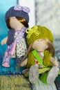 Little rag dolls dressed in polka dot dresses - light brown and blue, - knitted hats with bows, knitted vests, sneakers