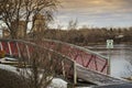 Little red bridge in Desmarchais park  beside the St-Lawrence river Royalty Free Stock Photo