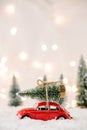 Little red car toy carrying Christmas tree Royalty Free Stock Photo