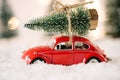 Little red car toy carrying Christmas tree Royalty Free Stock Photo