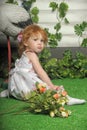 Little red-haired girl in a white dress with a bouquet of flowers Royalty Free Stock Photo