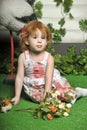 Little red-haired girl in a white dress with a bouquet of flowers Royalty Free Stock Photo