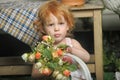 Little red-haired girl in a white dress with a bouquet of flowers Royalty Free Stock Photo