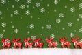 Little red reindeers on green ground and snowflakes- decoration for Christmas time Royalty Free Stock Photo