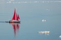 Little red sailboat cruising among floating icebergs in Disko Bay glacier during midnight sun season of polar summer. Greenland Royalty Free Stock Photo