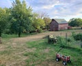 A little red wagon with gardening gloves sitting in front of an old red barn in Nebraska. Royalty Free Stock Photo