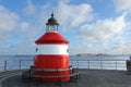 Little red and white lighthouse at Langelinie and the view of Trekroner Fort and windmills under blue sky Royalty Free Stock Photo