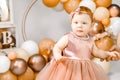 Little redhead baby girl celebrates first birthday anniversary. 1 year family baloons party. Professional photoshoot