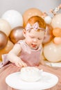 Little redhead baby girl celebrates first birthday. Cake crash smash, hands eating. 1 year family baloons party