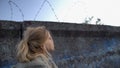 Little refugee girl looking at barbed wire, dreaming of new homeland, migration