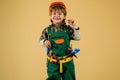 Little repairman. Kid boy in builders uniform and helmet with repair tools. Child game. Little boy plays construction worker. Royalty Free Stock Photo