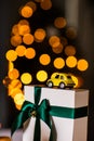 Little retro yellow toy model car with present gift box on gold bokeh background. Christmas, birthday, valentines day, delivery Royalty Free Stock Photo