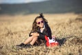 Little rock girl sitting in the field with a toy guitar Royalty Free Stock Photo
