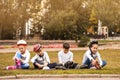 Little roller skaters sitting on grass Royalty Free Stock Photo