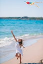 Little girl flying a kite on beach at sunset Royalty Free Stock Photo