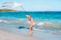 Little running girl with flying kite on tropical beach. Kid play on ocean shore. Royalty Free Stock Photo