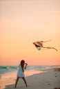 Little running girl with flying kite on tropical beach. Kid play on ocean shore. Royalty Free Stock Photo