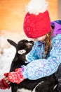 Little Russian Girl With Goatling In Village In Winter Close-Up