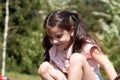 Little sad beautiful girl in a pink t-shirt with pigtails on the playground Royalty Free Stock Photo