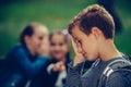 Little sad boy feeling left out, teased and bullied by his classmates Royalty Free Stock Photo