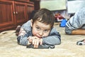 A little sad boy with a pensive look. Little boy playing toy cars at home on the carpet Royalty Free Stock Photo