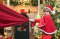 Little Santa Claus pulling huge bag of gifts on Christmas background. Santa child. Merry christmas and happy new year Royalty Free Stock Photo