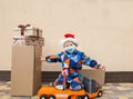 Little Santa helper in medical mask with painted funny smile, delivery of goods