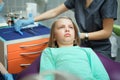 Little scared girl sitting in chair in dentist doctor office. Kid,child afraid of tooth extraction, teeth treatment