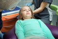 Little scared girl sitting in chair in dentist doctor office. Kid,child afraid of tooth extraction, teeth treatment