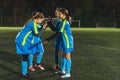 little school age girls having a break during football practice in a stadium, full shot Royalty Free Stock Photo