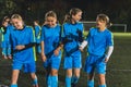 little school-age girls in soccer uniforms having fun during a break at the practice, football stadium Royalty Free Stock Photo