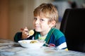 Little school boy eating pasta indoor in a canteen. Royalty Free Stock Photo