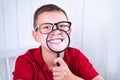 Little school boy express positive and negative emotions through a magnifying glass. Go back to school. Educat how to Royalty Free Stock Photo