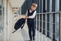 Little school boy in uniform walking in corridor with backpack