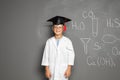 Little school child in laboratory uniform with graduate cap Royalty Free Stock Photo