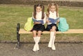 Little school friends girls with backpacks, reading books concept Royalty Free Stock Photo