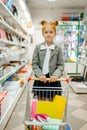 Little school girl with cart, stationery store Royalty Free Stock Photo